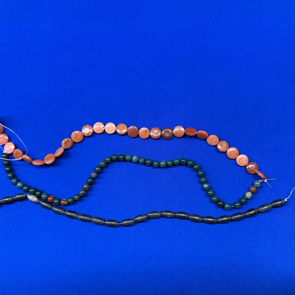 Bundle of Chicken Blood, Flat Round Goldstone, and Black Bicone Horn beads.